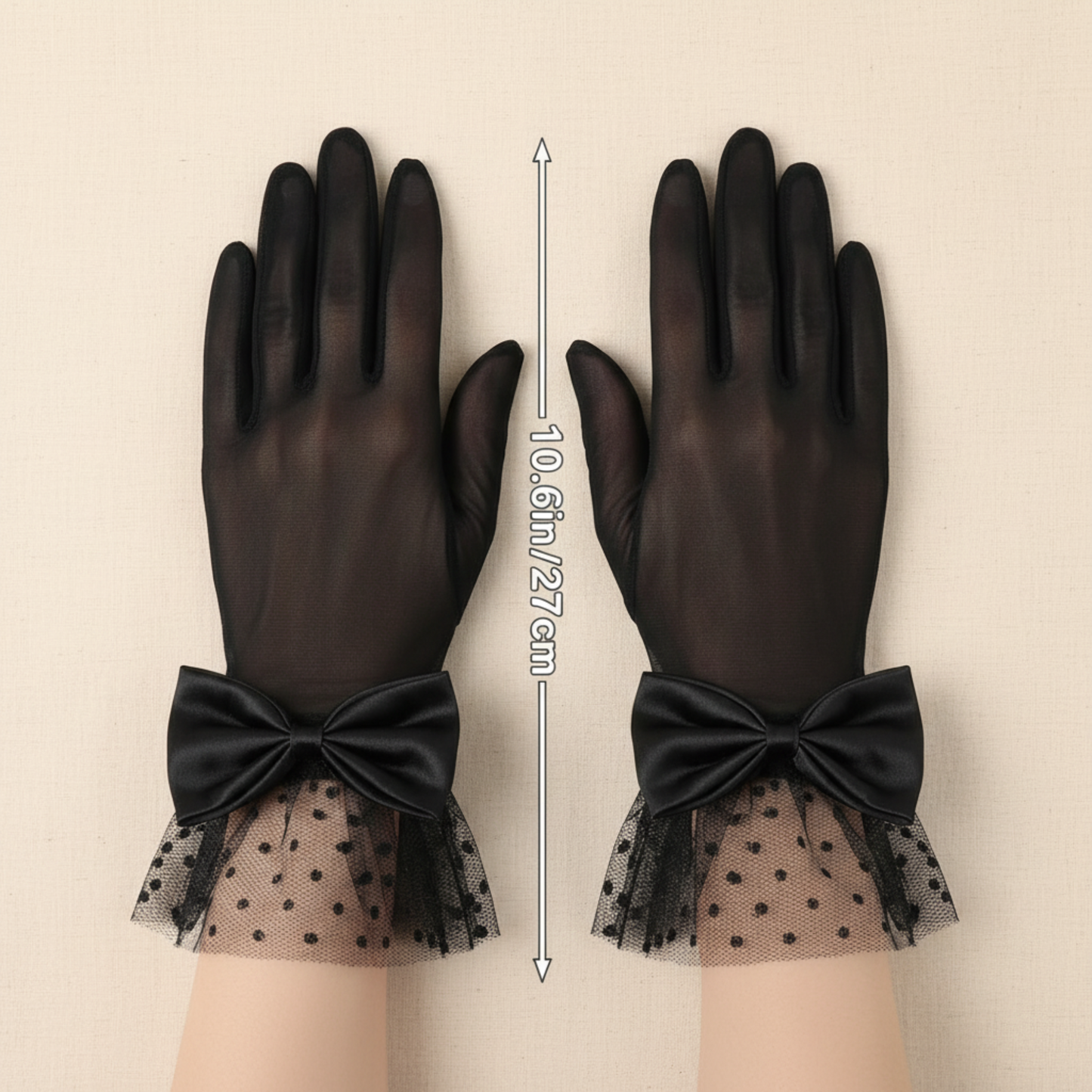 Black sheer mesh bow gloves worn with hands crossed, close-up