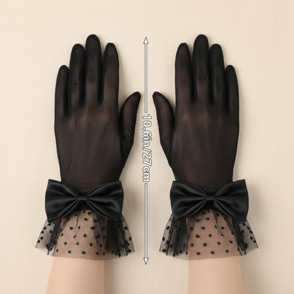 Black sheer mesh bow gloves worn with hands crossed, close-up