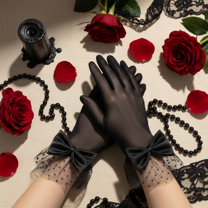 Black sheer mesh bow gloves with hands crossed near red roses and pearls