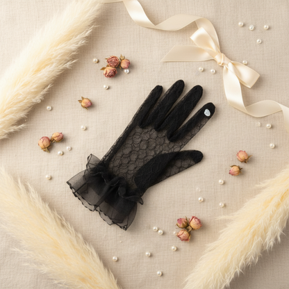 Black lace bridal glove flat lay with feathers and pearls