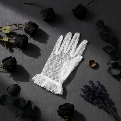 White lace bridal glove flat lay with dark floral accents