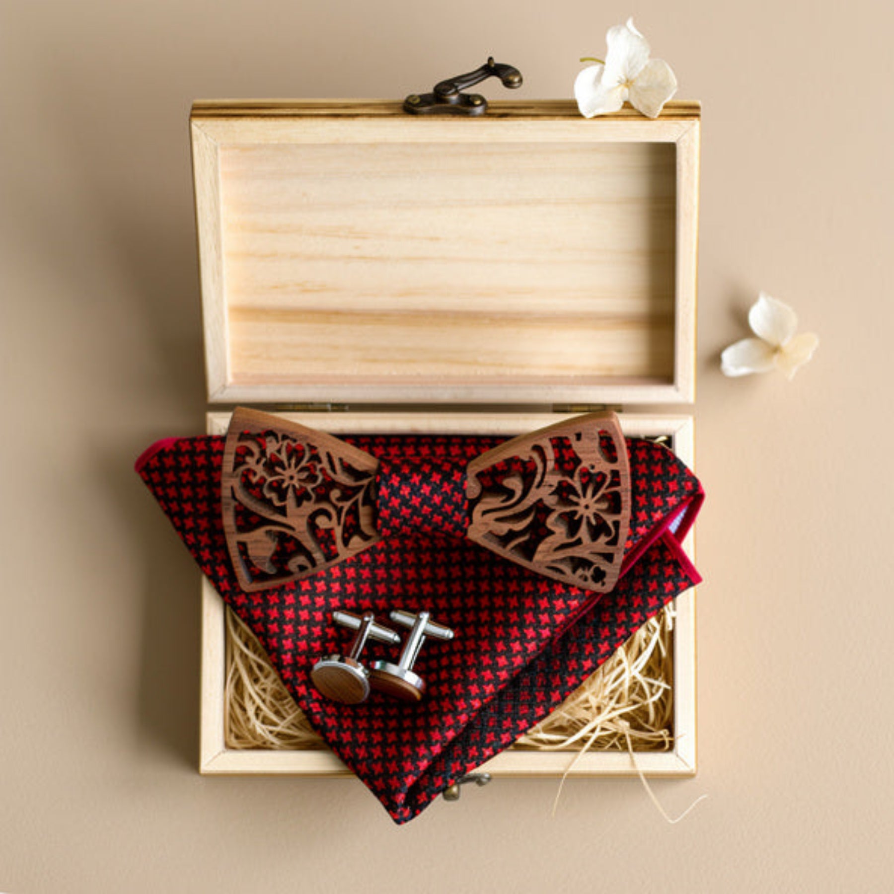 Walnut bow tie, pocket square, and cufflinks in open wooden box on cream fabric