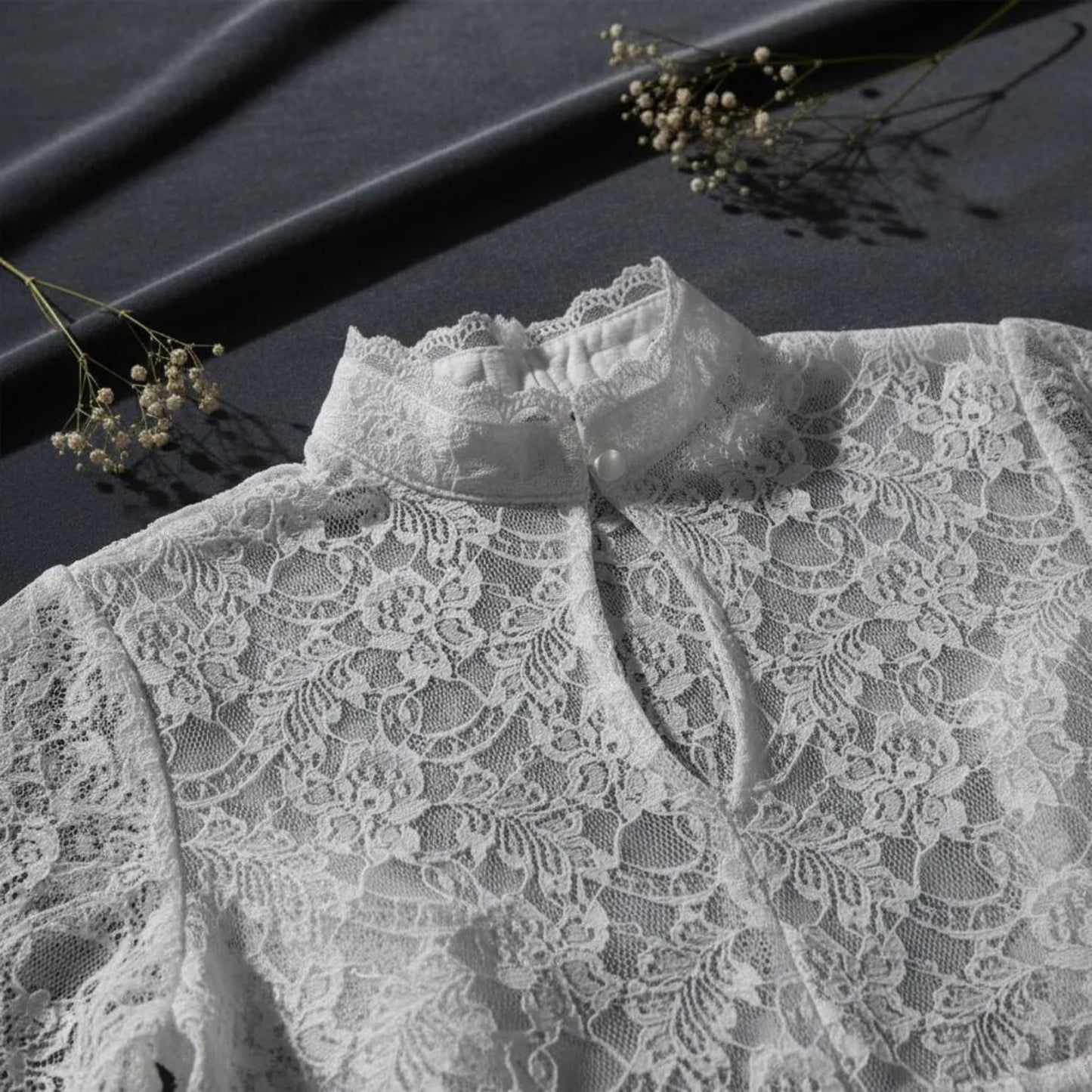 Close-up detail of white floral lace fabric on dark background