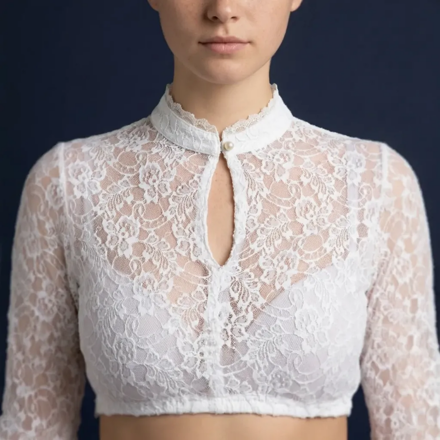 Close-up of white lace crop top scalloped neckline on blue background