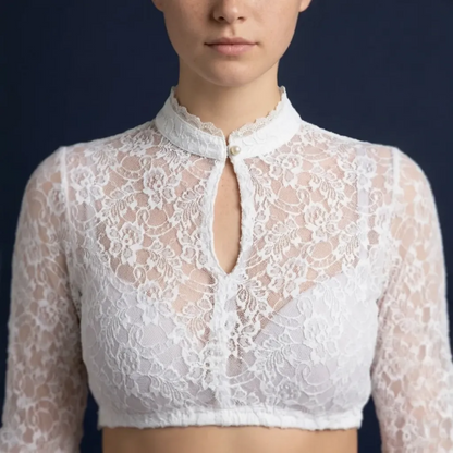 Close-up of white lace crop top scalloped neckline on blue background